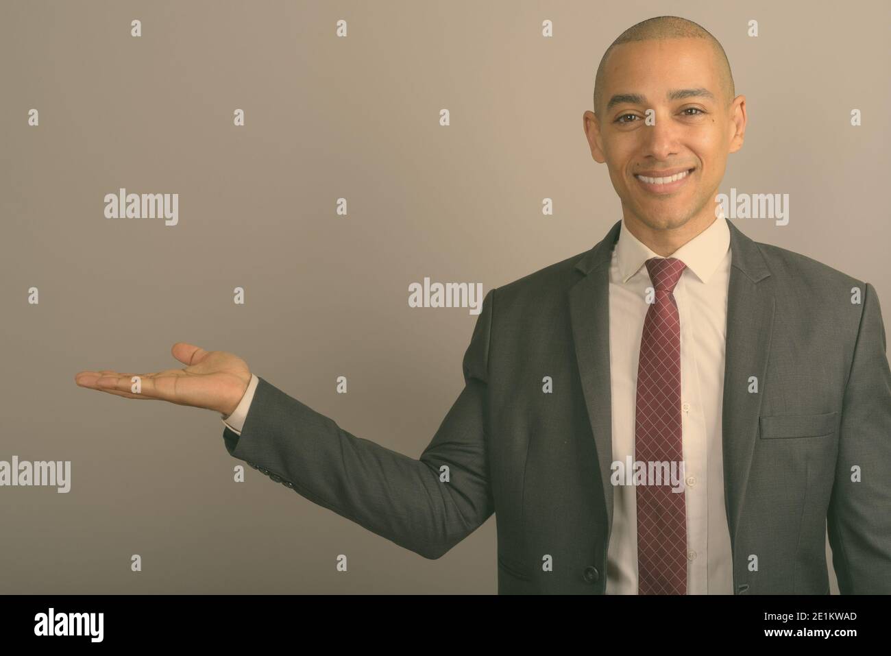 Handsome bald businessman wearing suit against gray background Stock ...