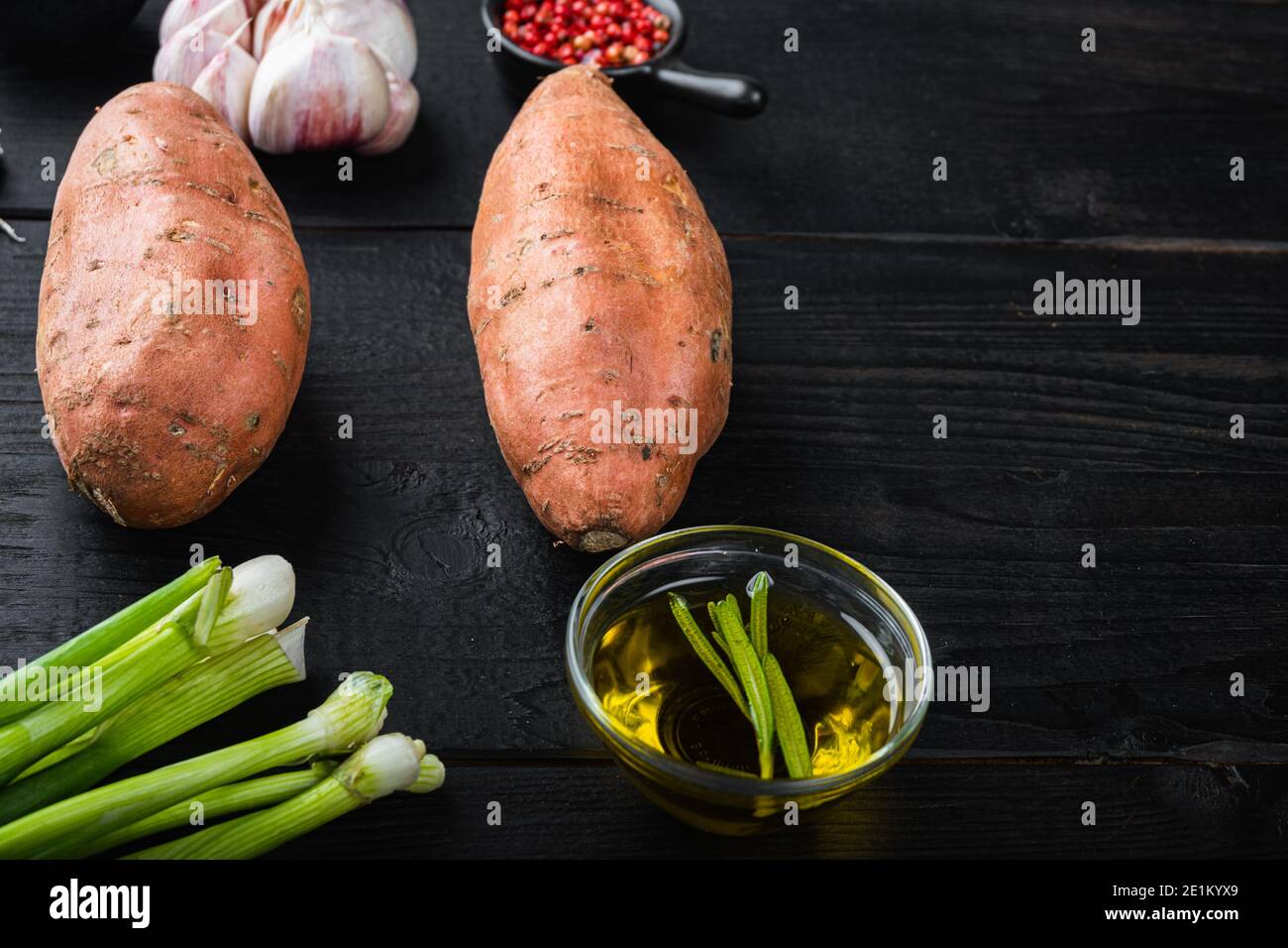 Sweet potato or batat with ingredients, on black wooden background with ...