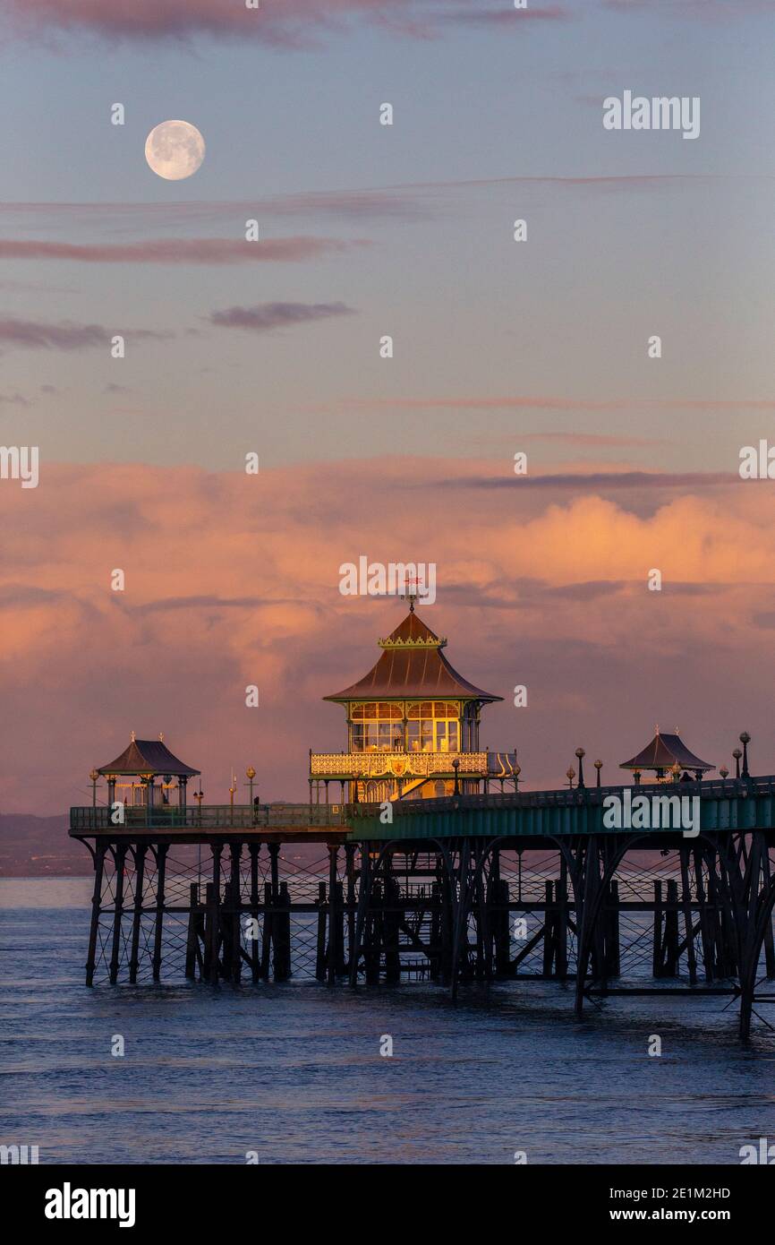 The moon sets behind Clevedon Pier in Somerset. Stock Photo