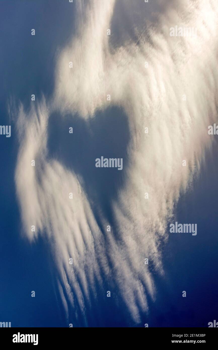Unique cloud formation resembling a heart shape in a clear blue sky ...