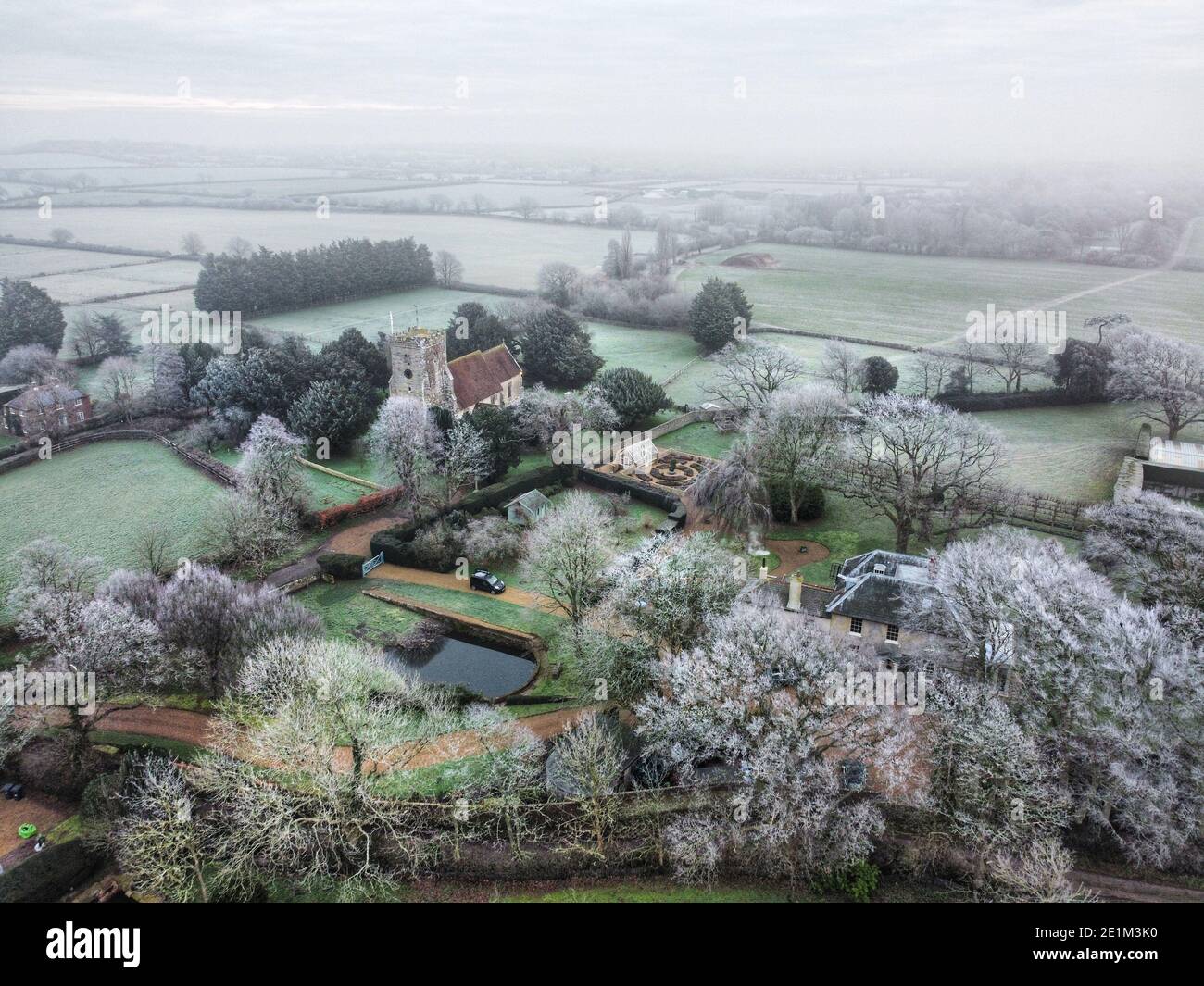 Ripe, East Sussex, UK. 8th Jan, 2021. Frost ices the trees surrounding Ripe's medieval church on a cold and frosty morning in rural East Sussex. Credit: Peter Cripps/Alamy Live News Stock Photo