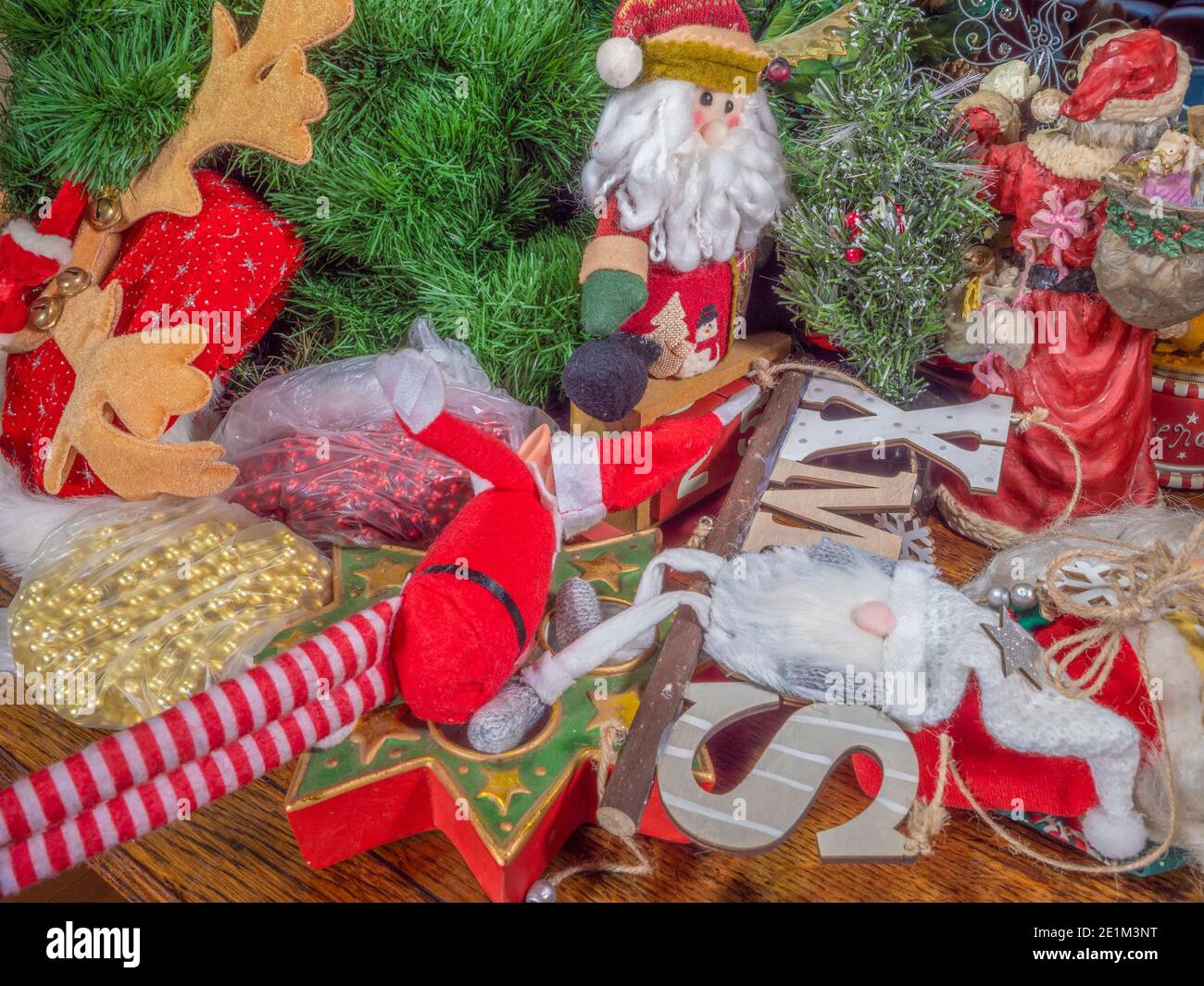 Christmas decorations, soft toys and ornaments piled up on a table, a