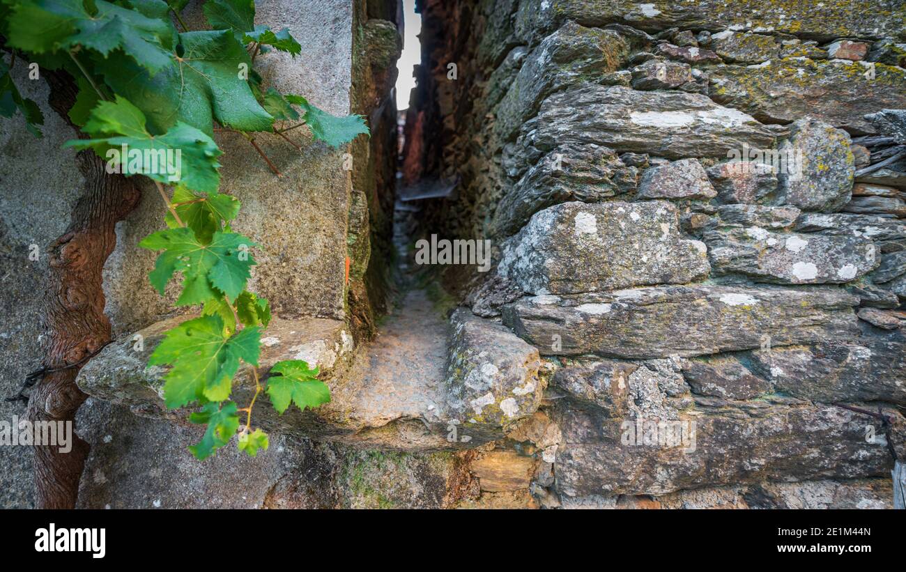 Antique water canalization between two vintage stone houses Stock Photo