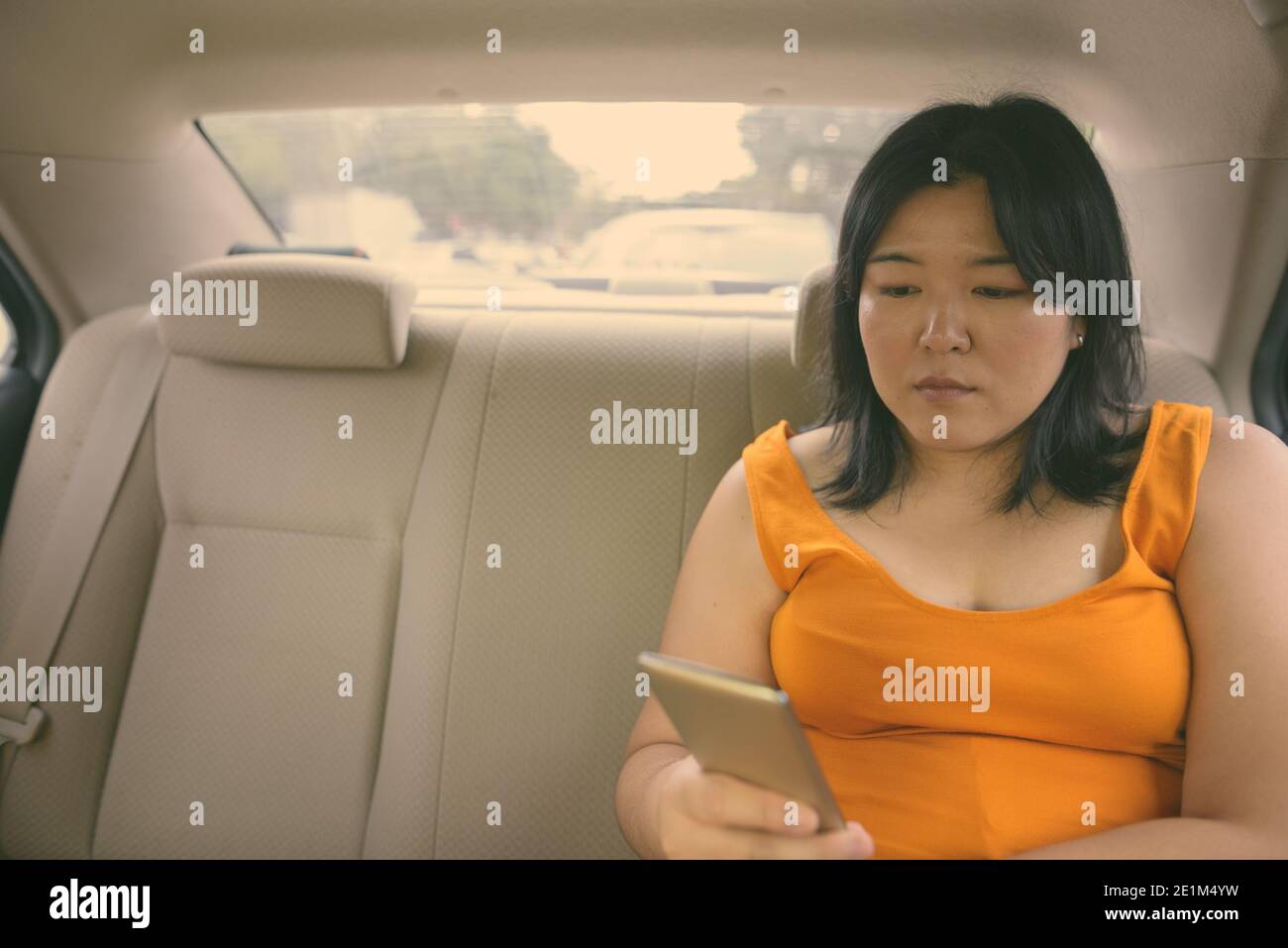 Beautiful overweight Asian woman inside the car around the city Stock Photo