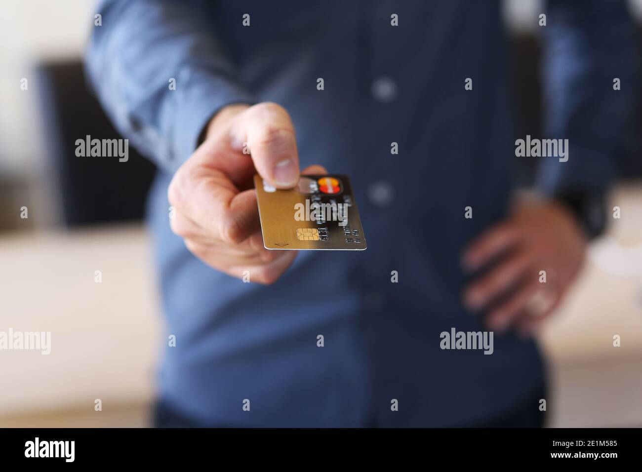 a young man holds out his bank card - payment card Stock Photo