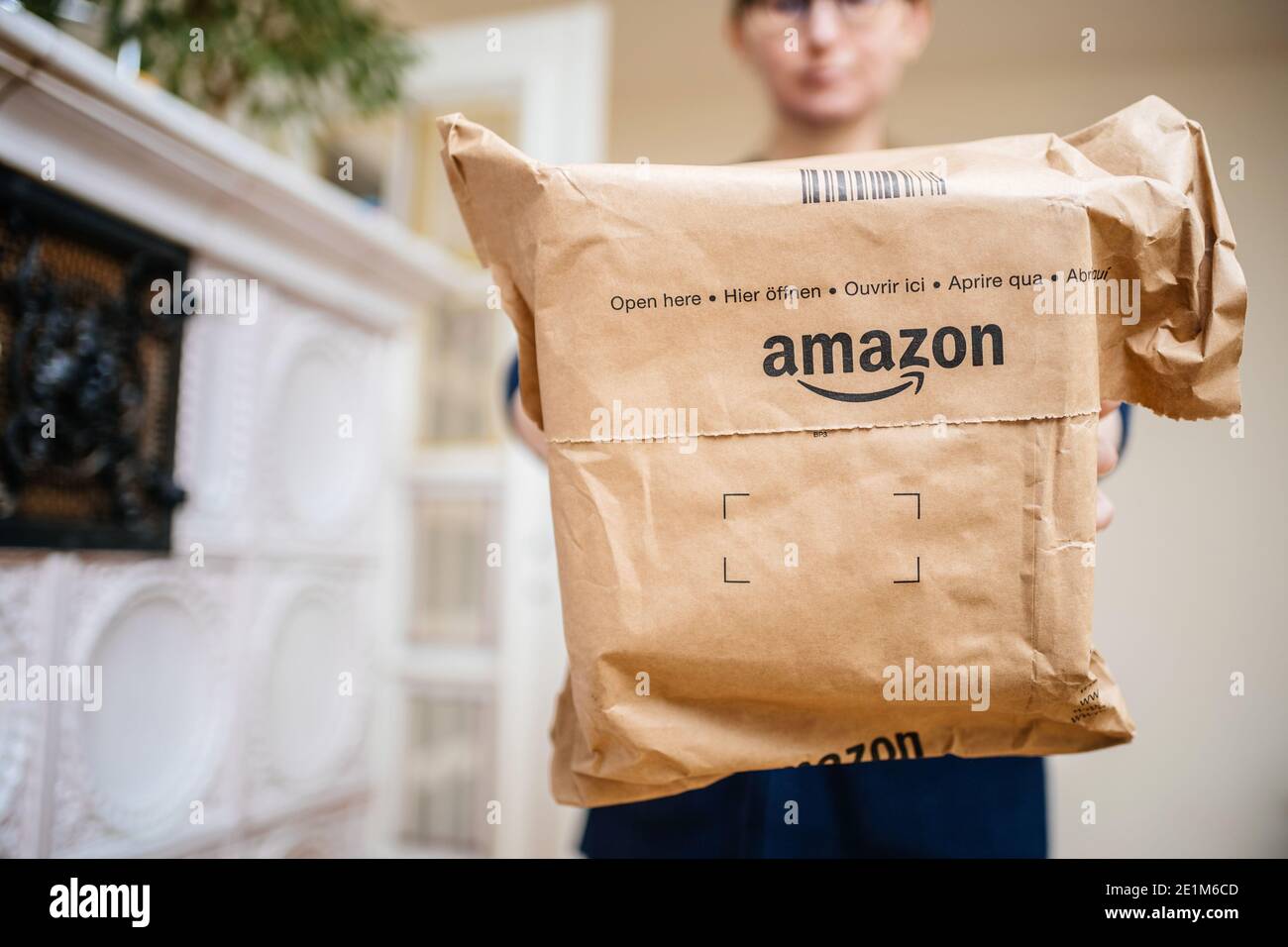 Paris, France - Dec 13, 2020: Front view of woman holding new design for the Amazon Prime package parcel with special indication markets open here in Stock Photo