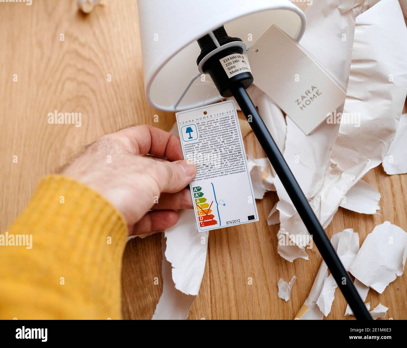 Paris, France - Dec 13, 2020: POV male hand holding paper tag of a Zara Home  table elegant lamp with ecological energy efficiency bulb recommendations  Stock Photo - Alamy