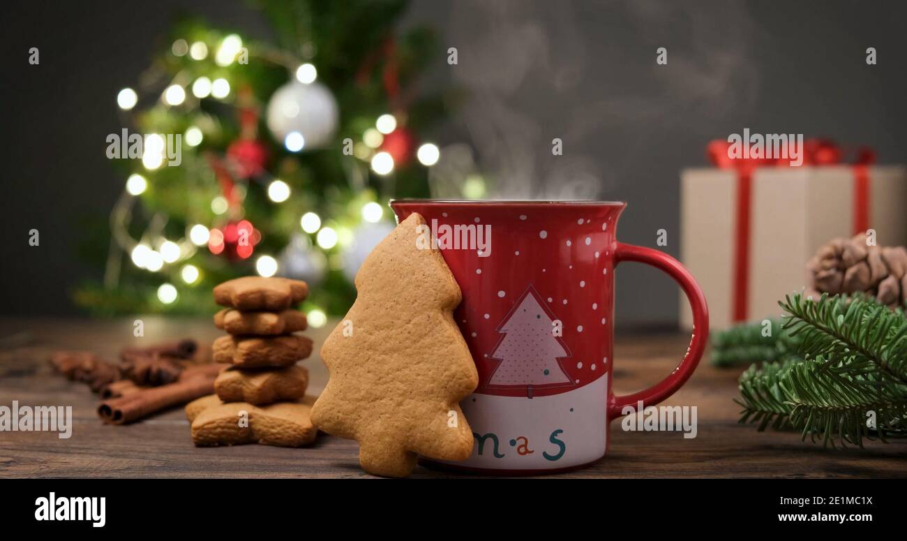 Gingerbread cookies and hot chocolate in a festive red cup in front of