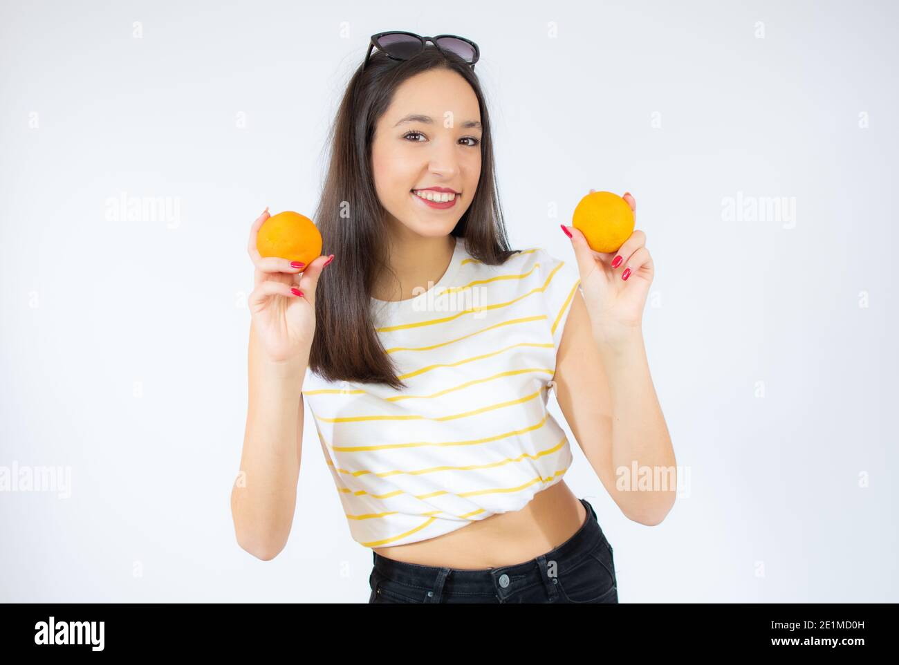 Teenager girl holding two oranges isolated on white background Stock ...