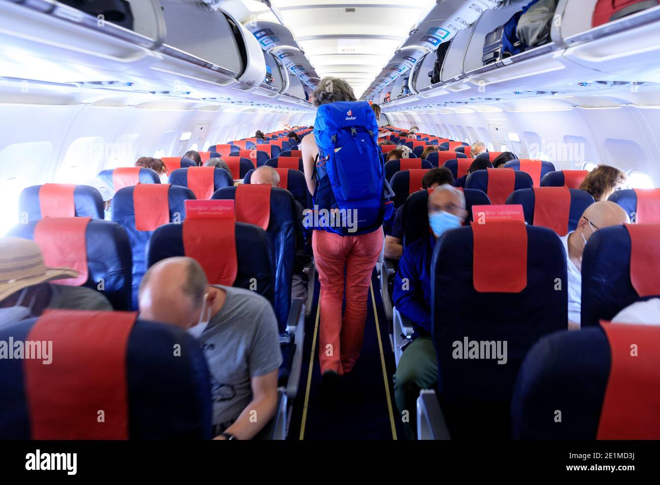 Interior view of a plane: passenger with a backpack walking in the main  aisle of an Airbus A319 belonging to Brussels Airlines. Passengers are  require Stock Photo - Alamy