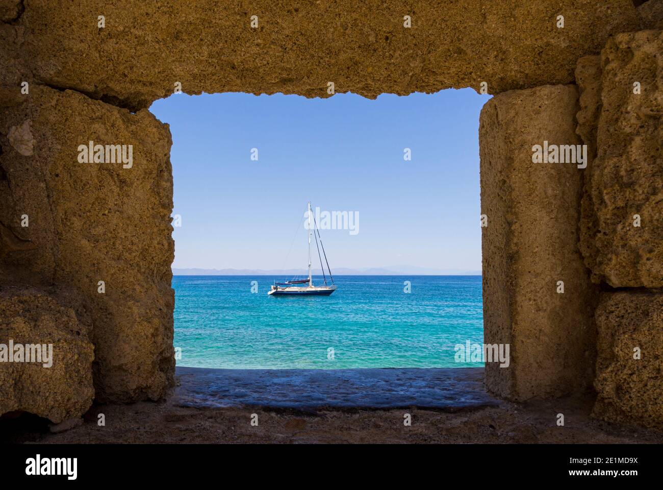 Yacht on the Aegean Sea framed through the old walls of Rhodes Town, Rhodes Isalnd, Dodecanese, Greece Stock Photo