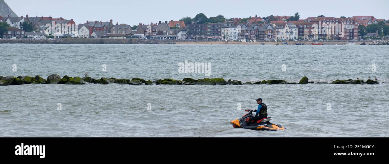A jet skier floats just off Colwyn Bay with a view of Rhos-on-Sea behind. Stock Photo