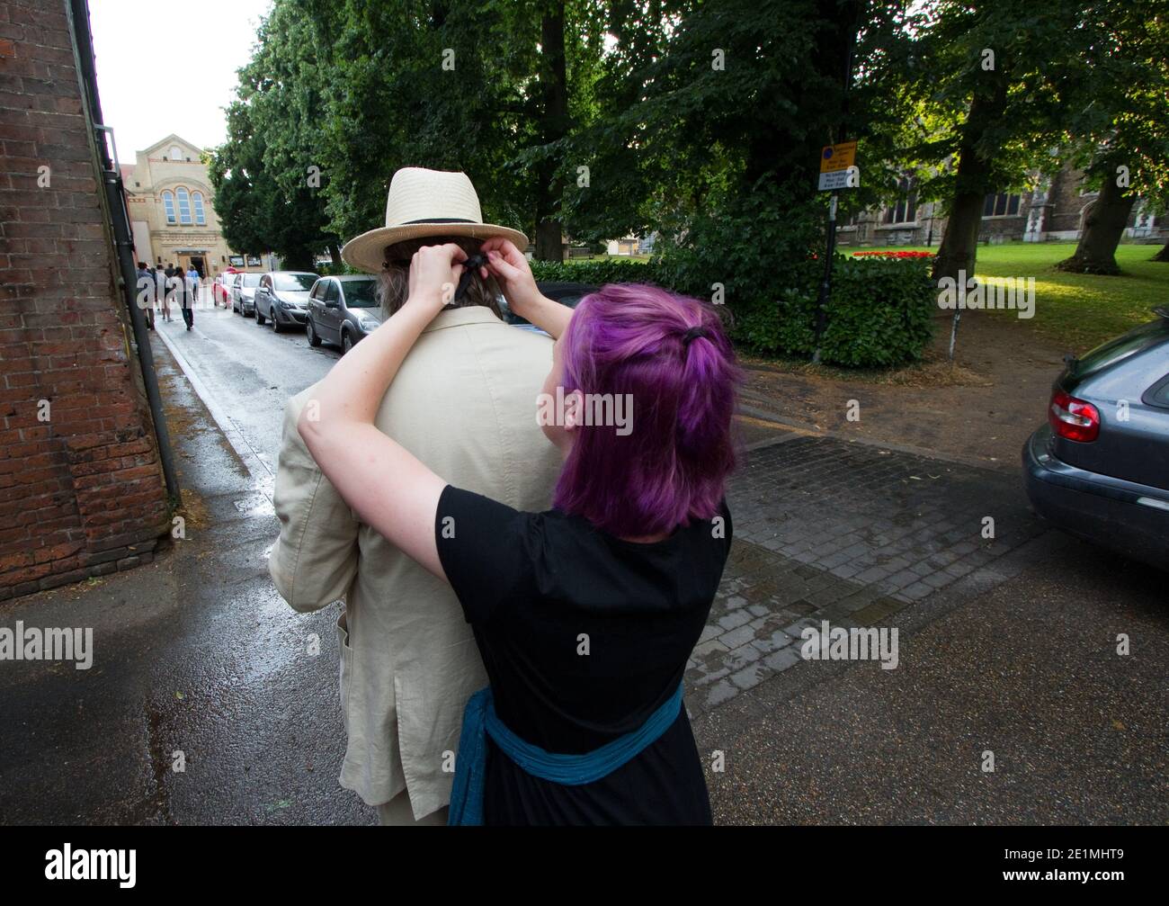 Actress with purple hair helps actor adjust his mask Stock Photo - Alamy