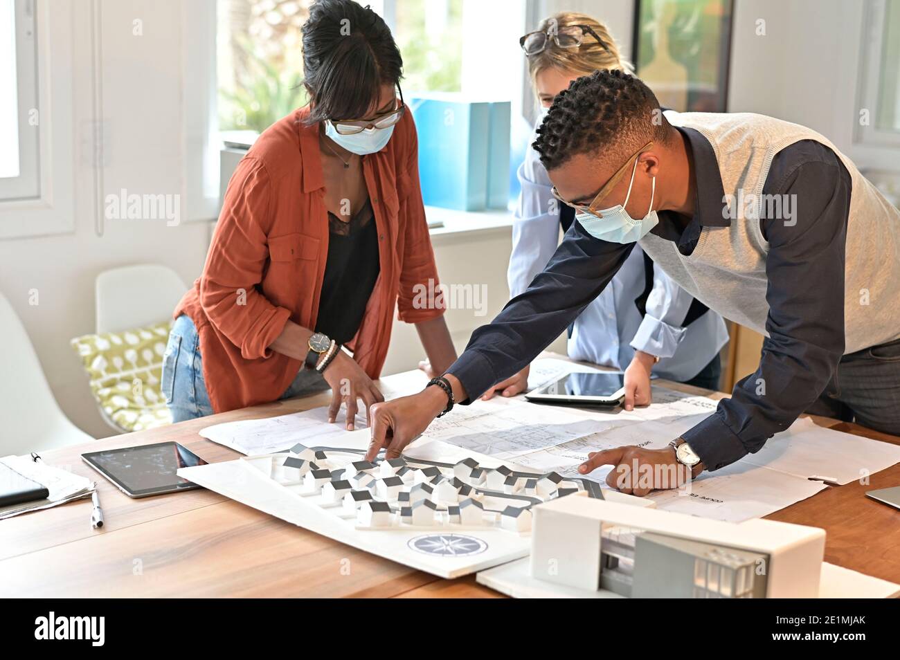 Team of architects working on project, wearing face mask in office Stock Photo