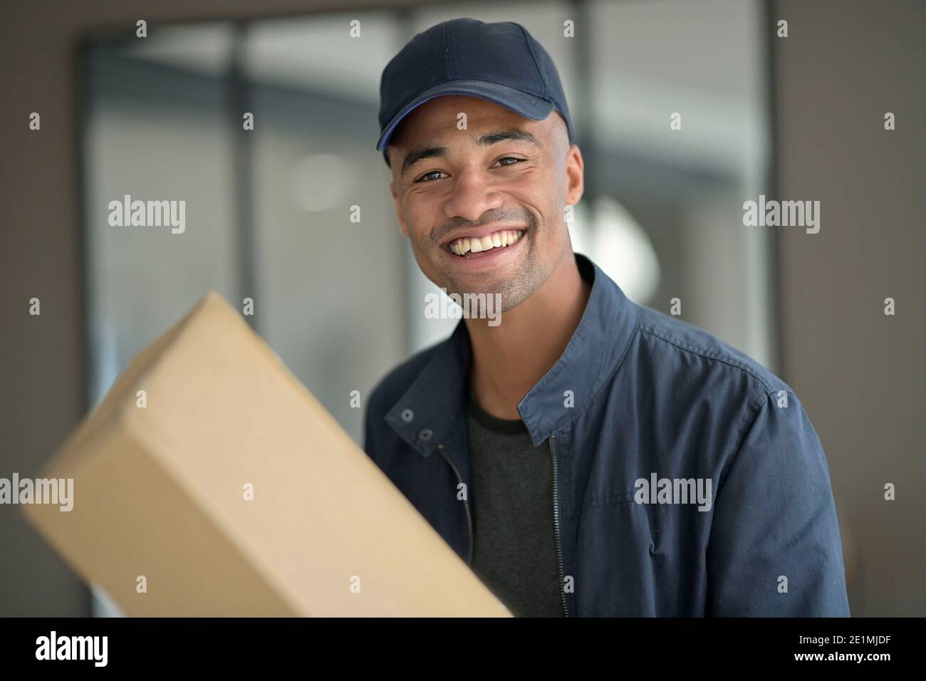 Portrait of afican-american delivery man holding craft box Stock Photo