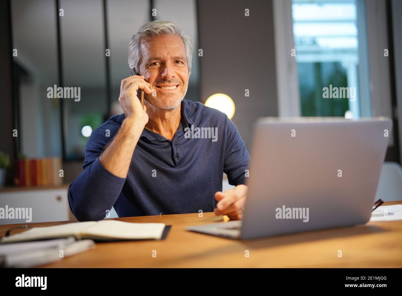 Portrait of senior man with grey hair connected with laptop Stock Photo