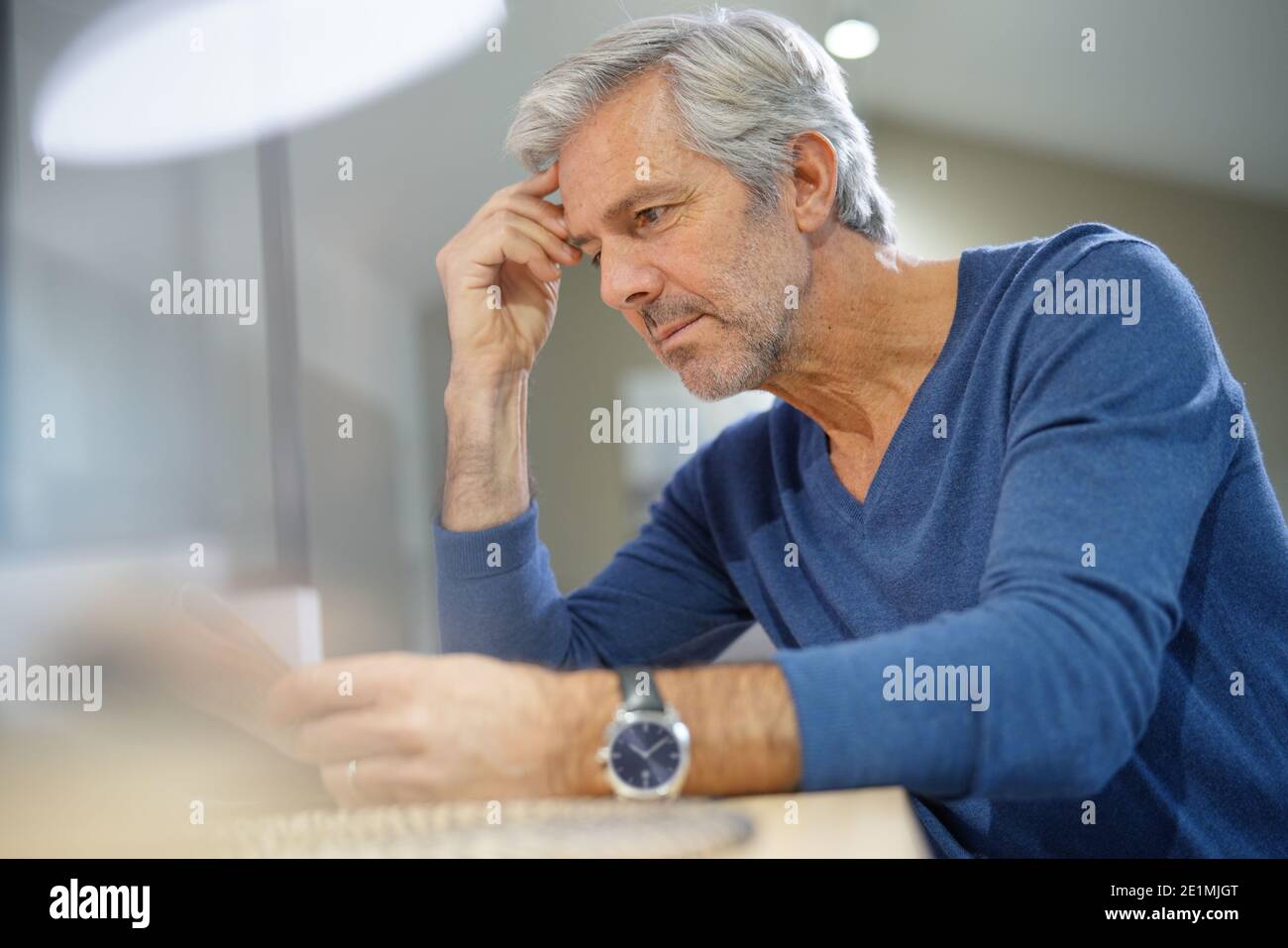 Senior man at home relaxing and reading newspaper Stock Photo