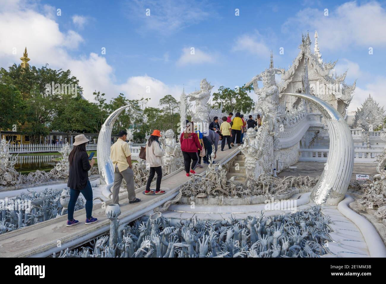 CHIANG RAY, THAILAND - DECEMBER 16, 2018: Tourists and pilgrims enter the White Temple (Wat Rong Khun) Stock Photo