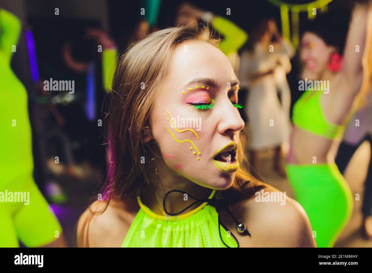 beautiful girl with lsd on tongue in nightclub with pink smoke Stock Photo