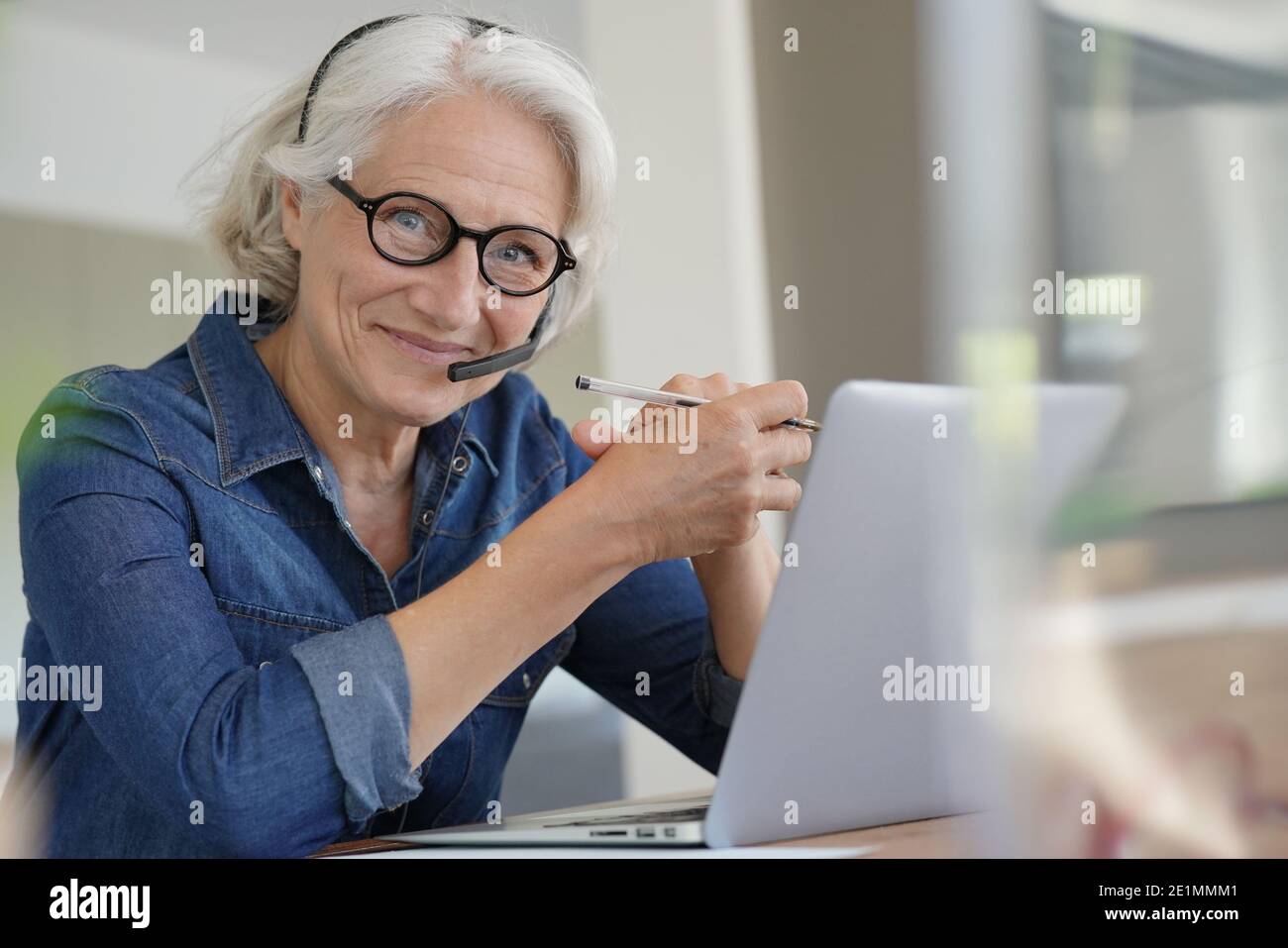 Active senior woman working from home on laptop Stock Photo