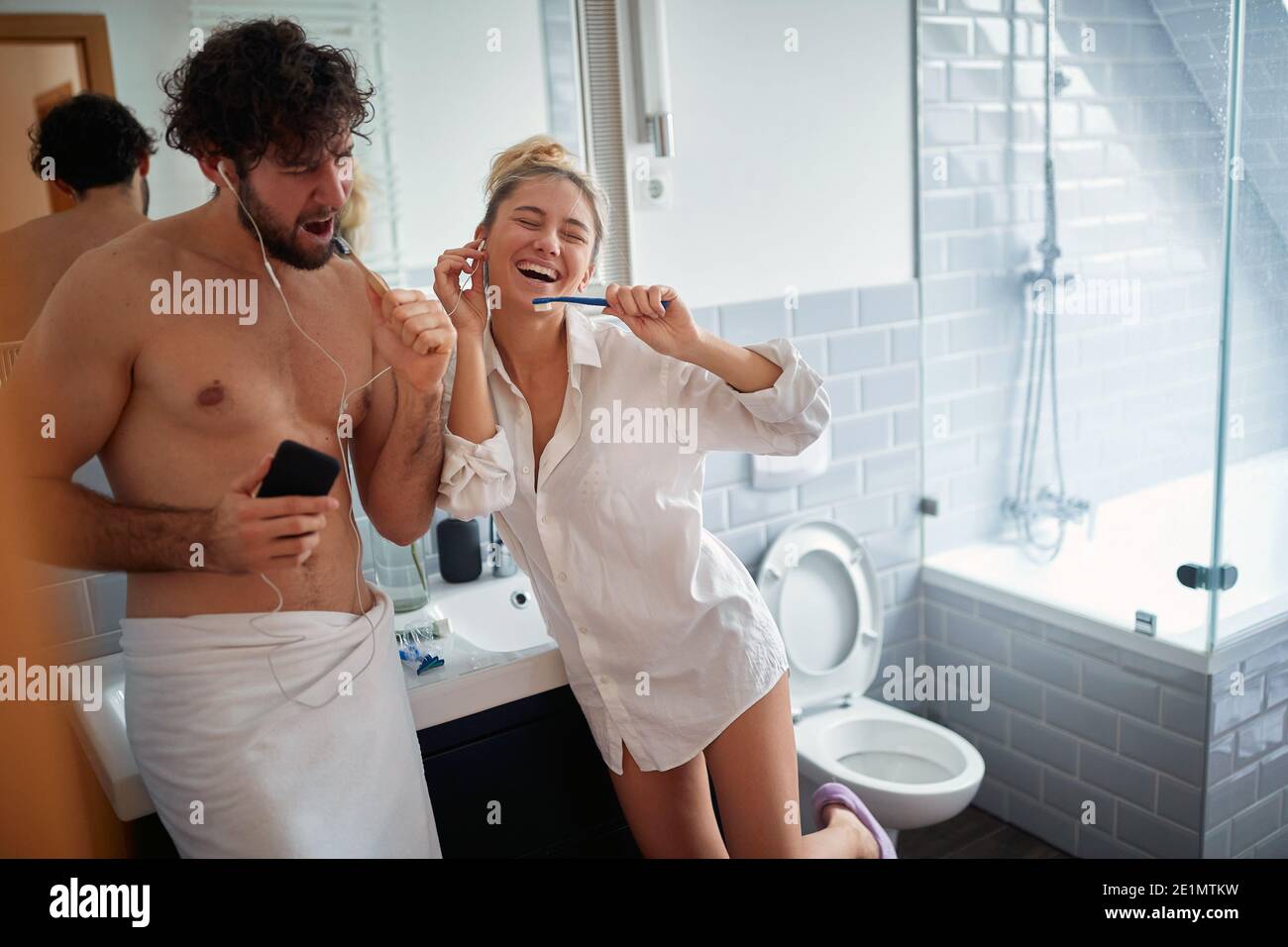 Happy couple brushing teeth together in the morning Stock Photo
