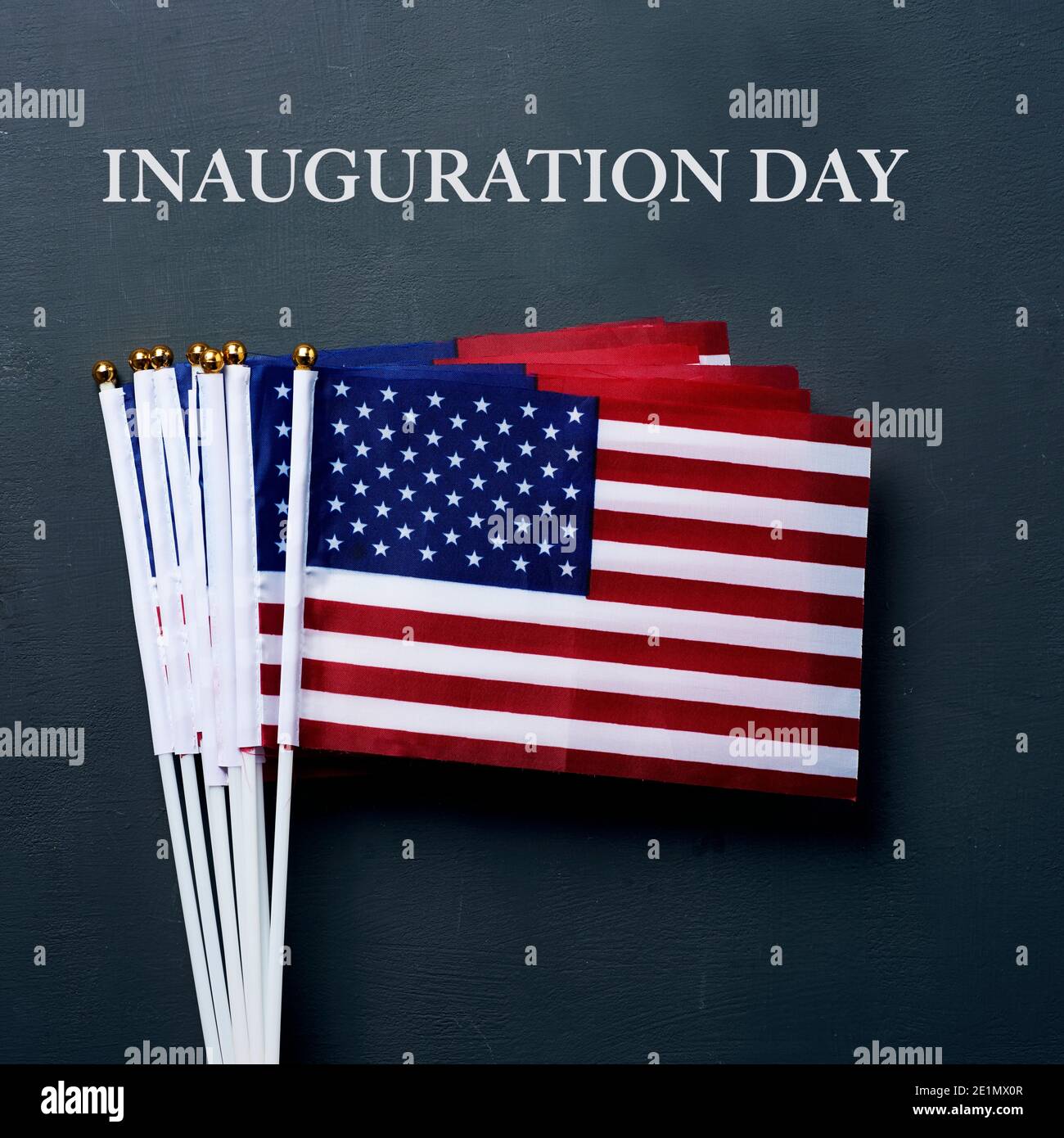 the text inauguration day and some american flags on a dark gray background Stock Photo