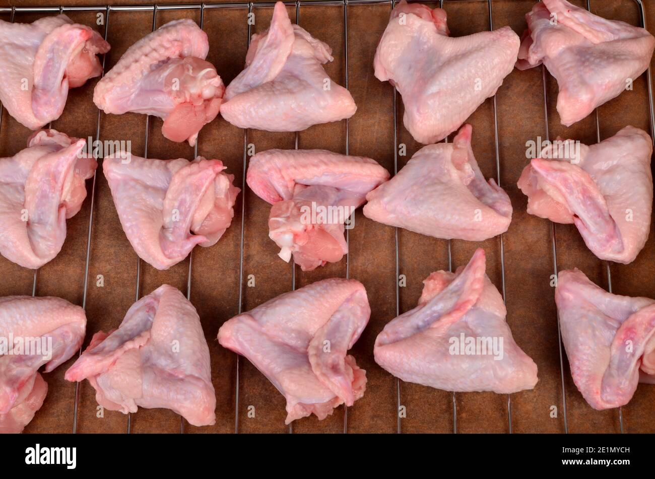 raw chicken wings triangle on metal grill. Raw chicken wings Stock