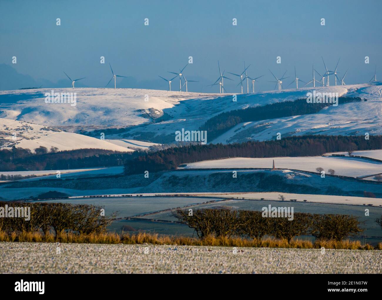 East Lothian, Scotland, United Kingdom, 8th January 2021. UK Weather: snow covers most of the county from the Garleton Hills southwards to the Lammermuir Hills on a bright clear sunny day with wind turbines clearly visible in the distance Stock Photo