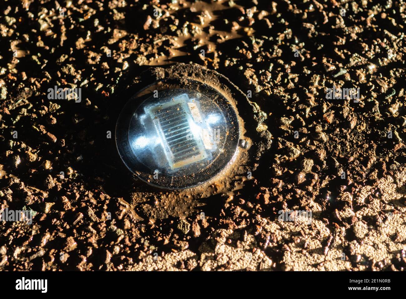 Solar powered LED road stud or cats eye illuminated at night on the A675 Belmont Road, Lancashire, England, UK Stock Photo