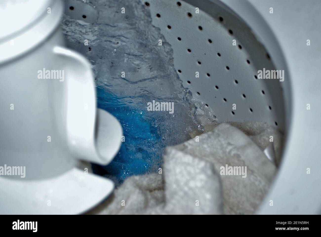 load of dirty towels in a washing machine filling with water Stock