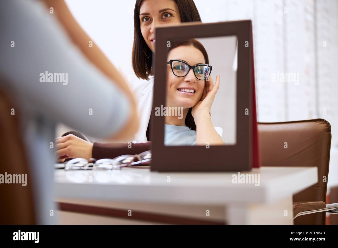 Customer adoring her appearance with fashionable glasses Stock Photo