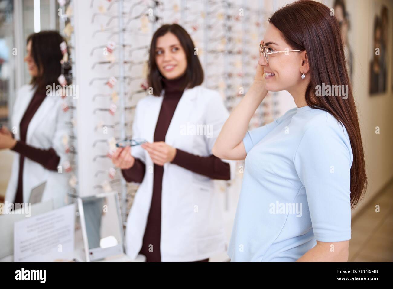 Client inspecting her appearance in a wall mirror Stock Photo