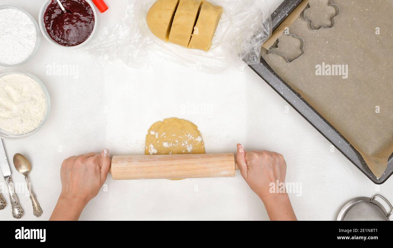 Woman hands roll cookie dough on kitchen table. Shortbread cookie