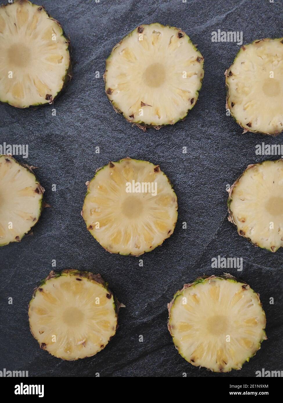 Sliced and chopped pineapple on a dark background Stock Photo