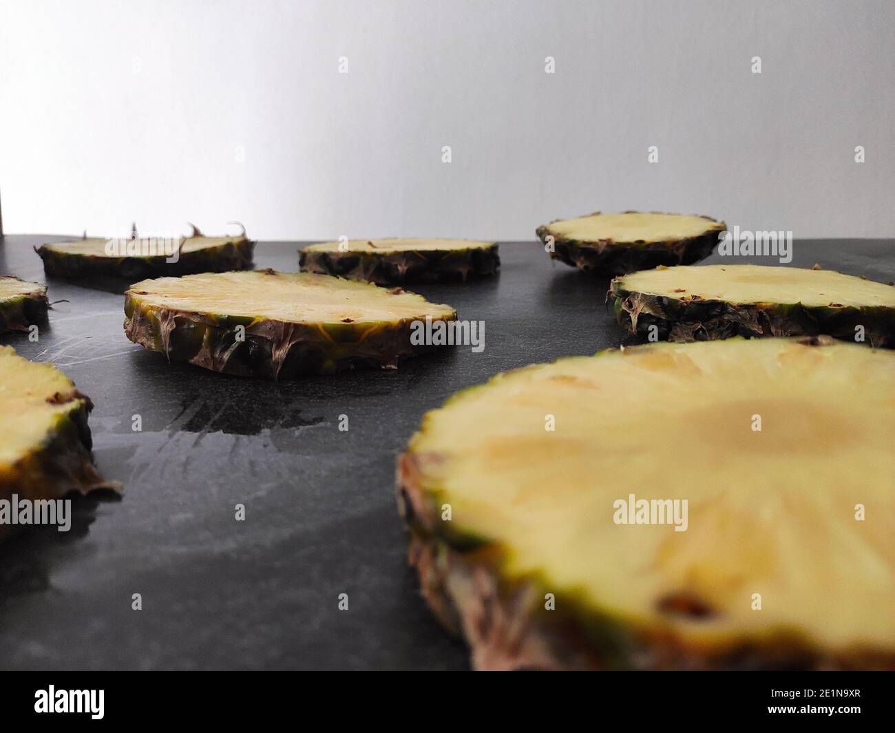 Sliced and chopped pineapple on a dark background Stock Photo