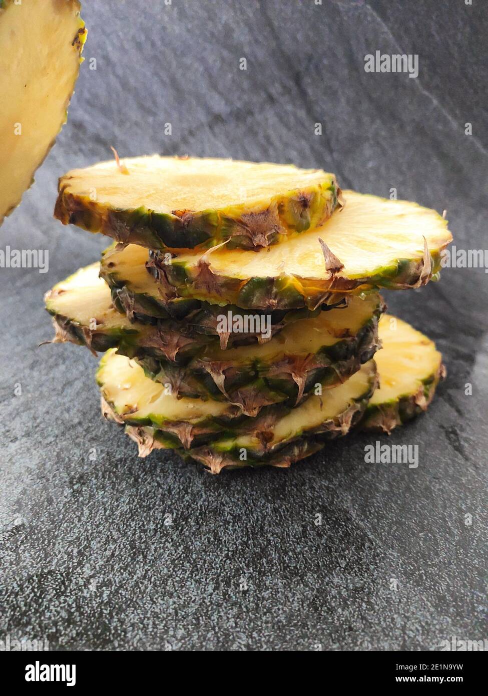 Sliced and chopped pineapple on a dark background Stock Photo