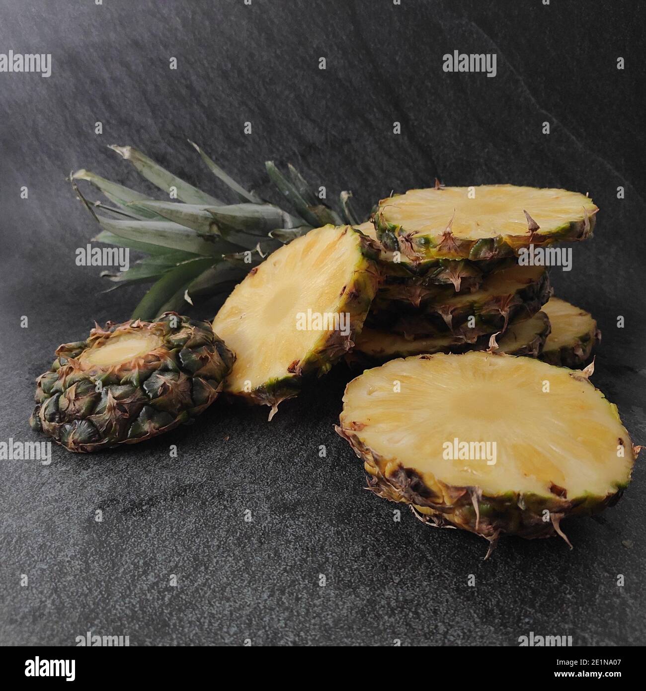Sliced and chopped pineapple on a dark background Stock Photo