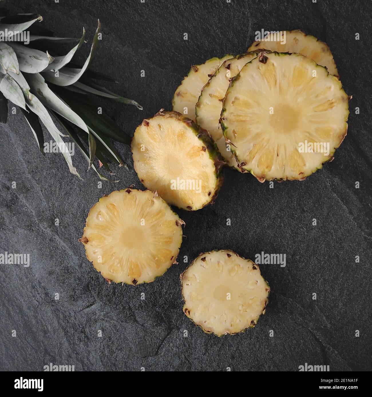 Sliced and chopped pineapple on a dark background Stock Photo