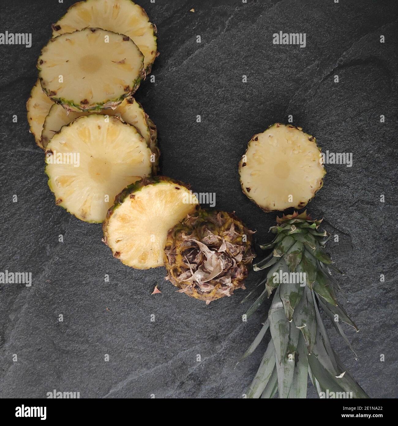 Sliced and chopped pineapple on a dark background Stock Photo