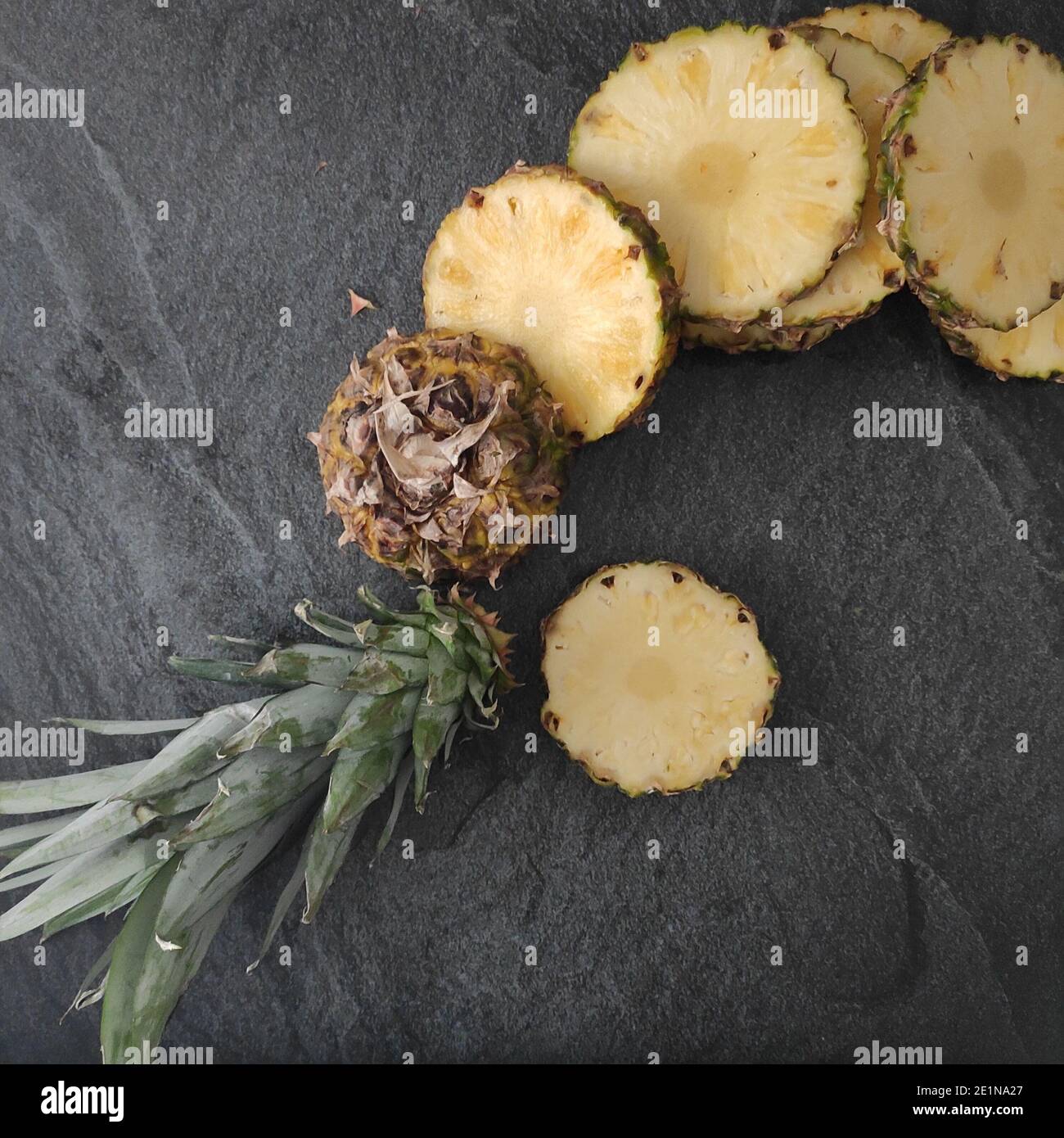 Sliced and chopped pineapple on a dark background Stock Photo