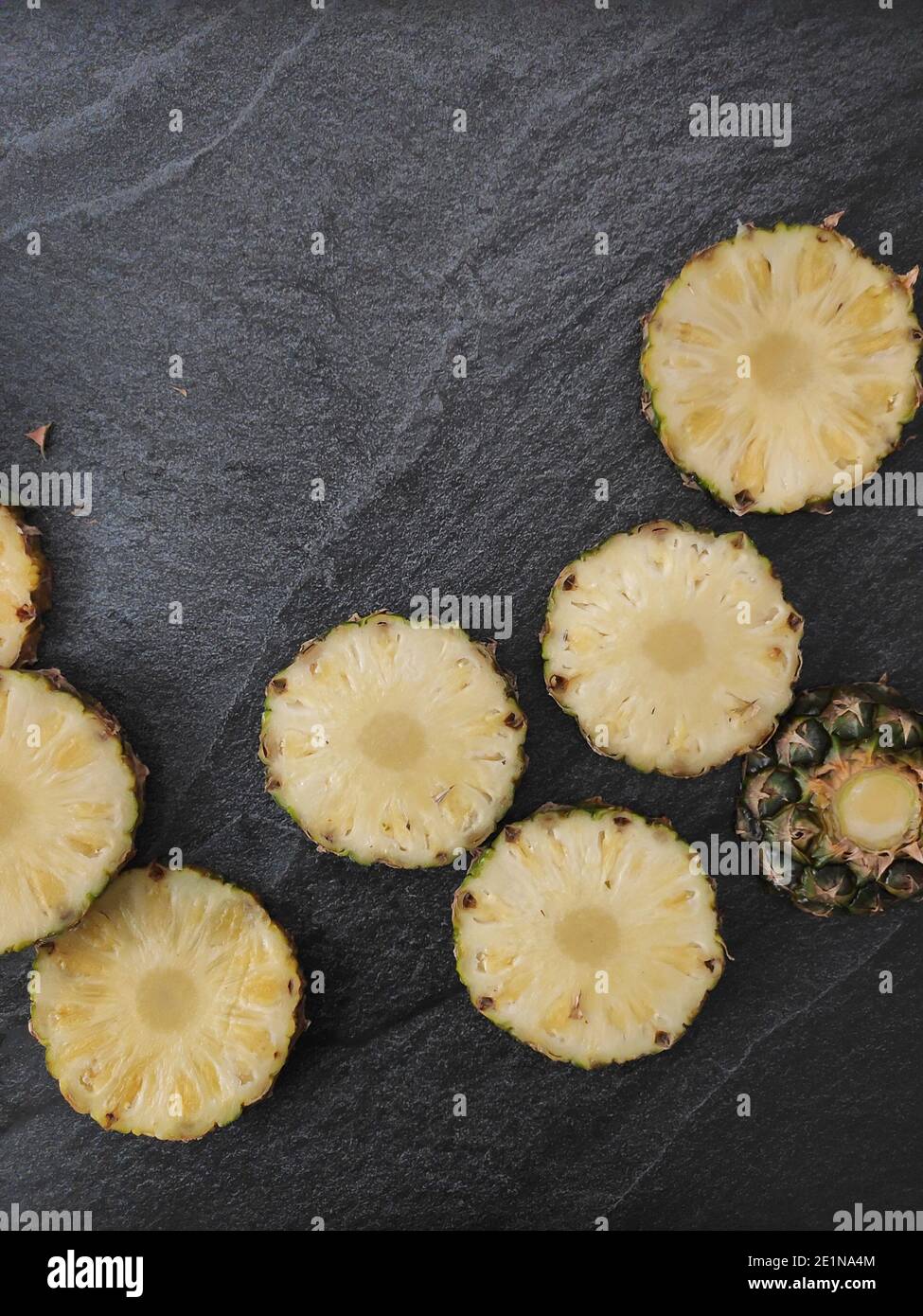 Sliced and chopped pineapple on a dark background Stock Photo