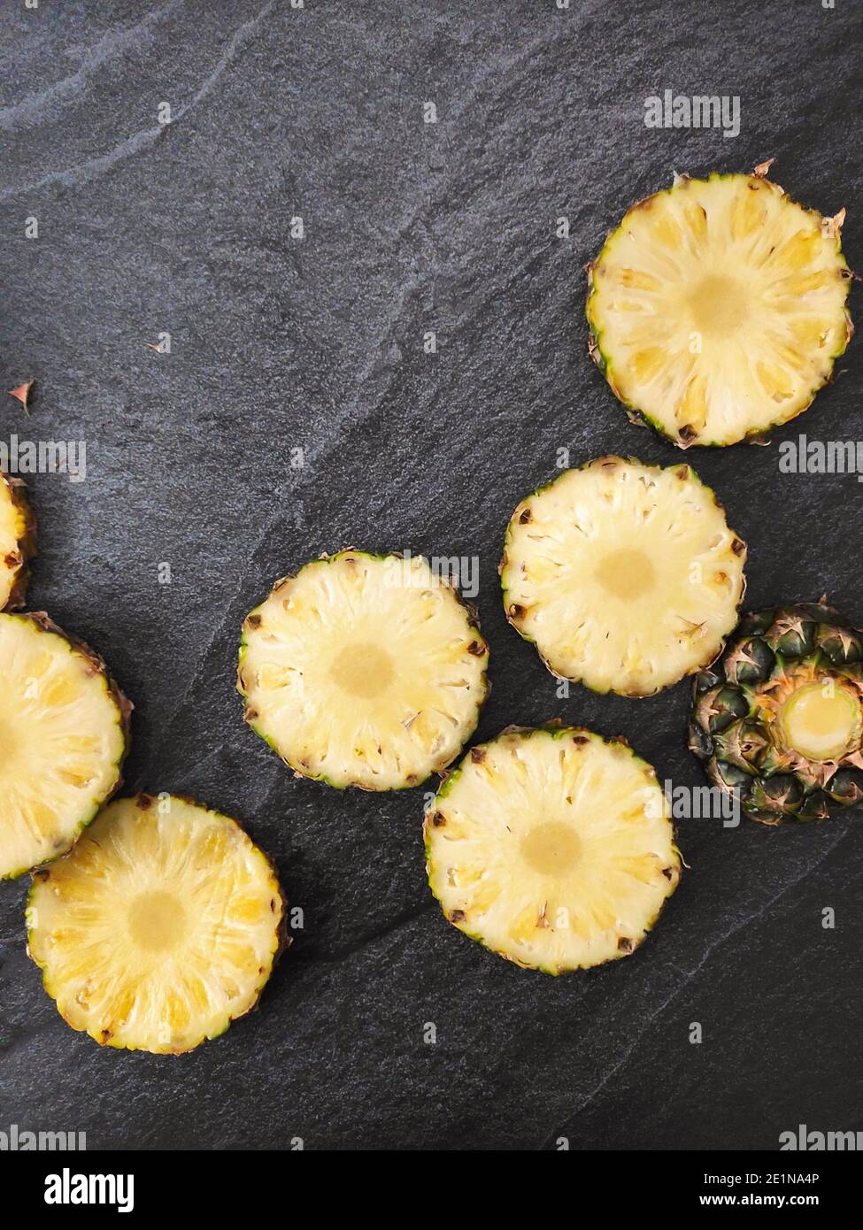 Sliced and chopped pineapple on a dark background Stock Photo