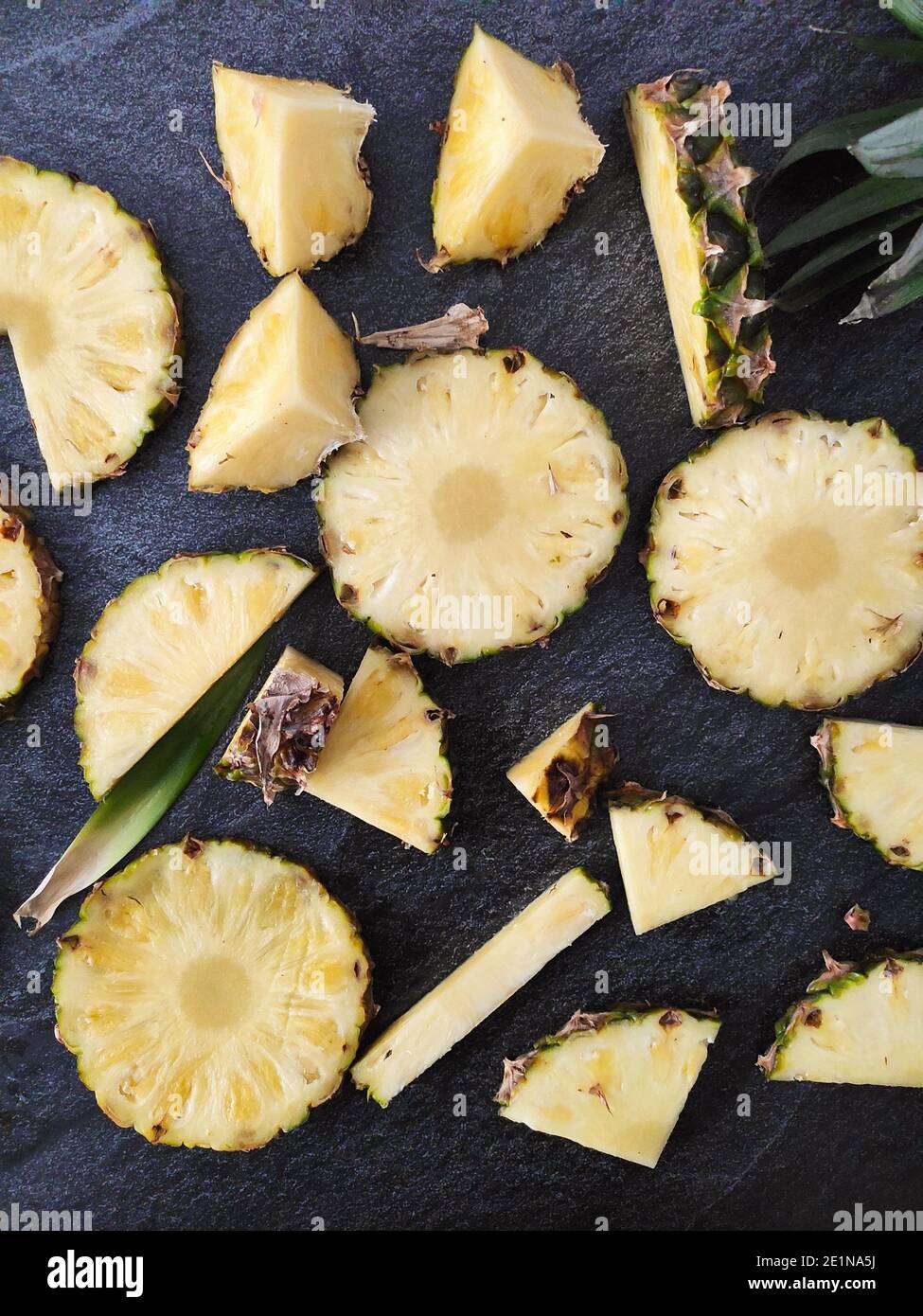 Sliced and chopped pineapple on a dark background Stock Photo