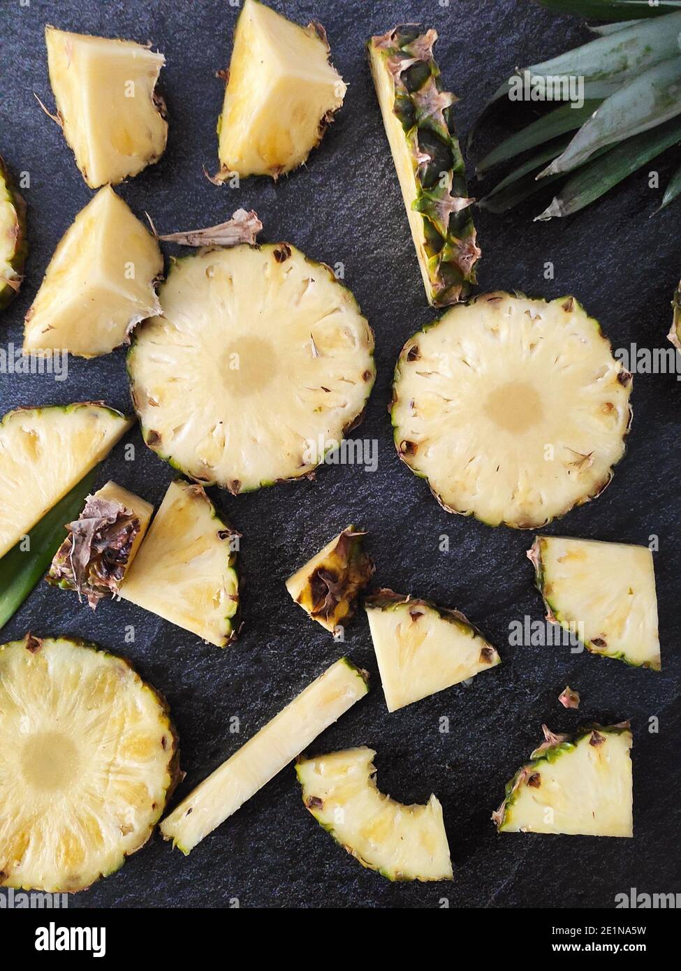 Sliced and chopped pineapple on a dark background Stock Photo