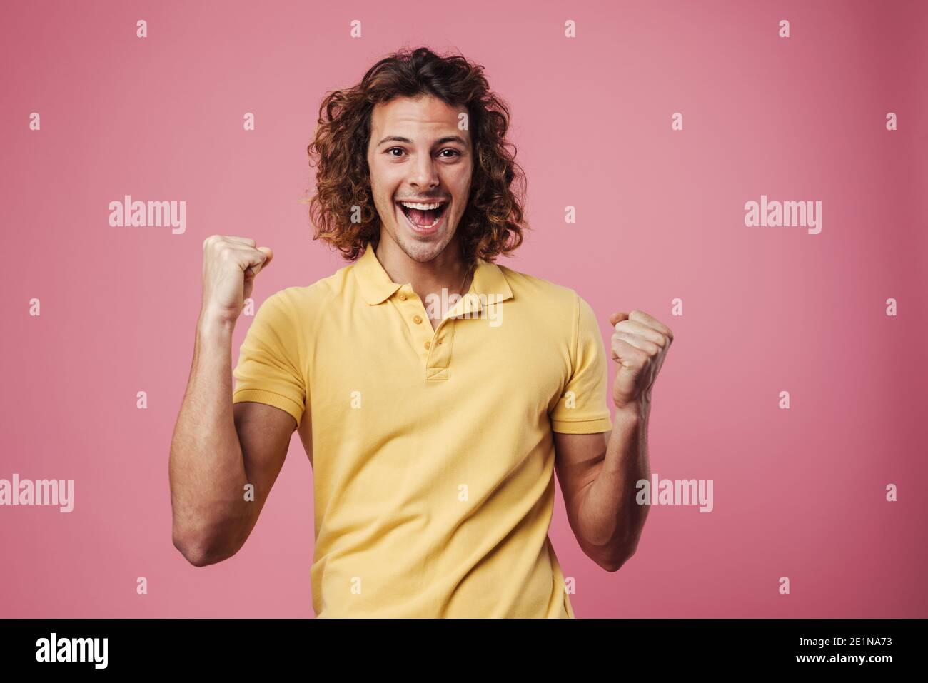 Excited handsome guy exclaiming and making winner gesture isolated over ...