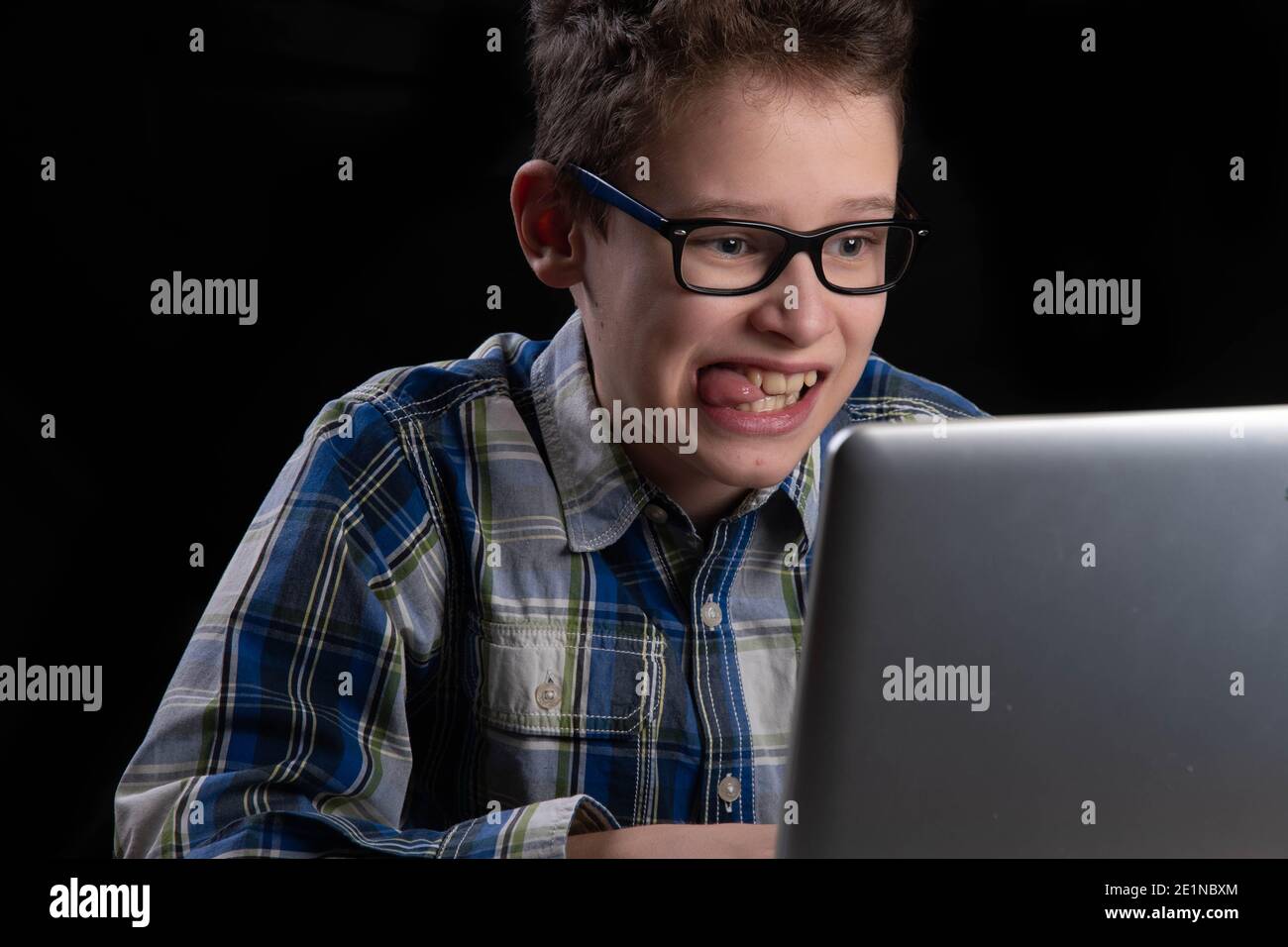 Boy funny on PC with tongue out on laptop Stock Photo