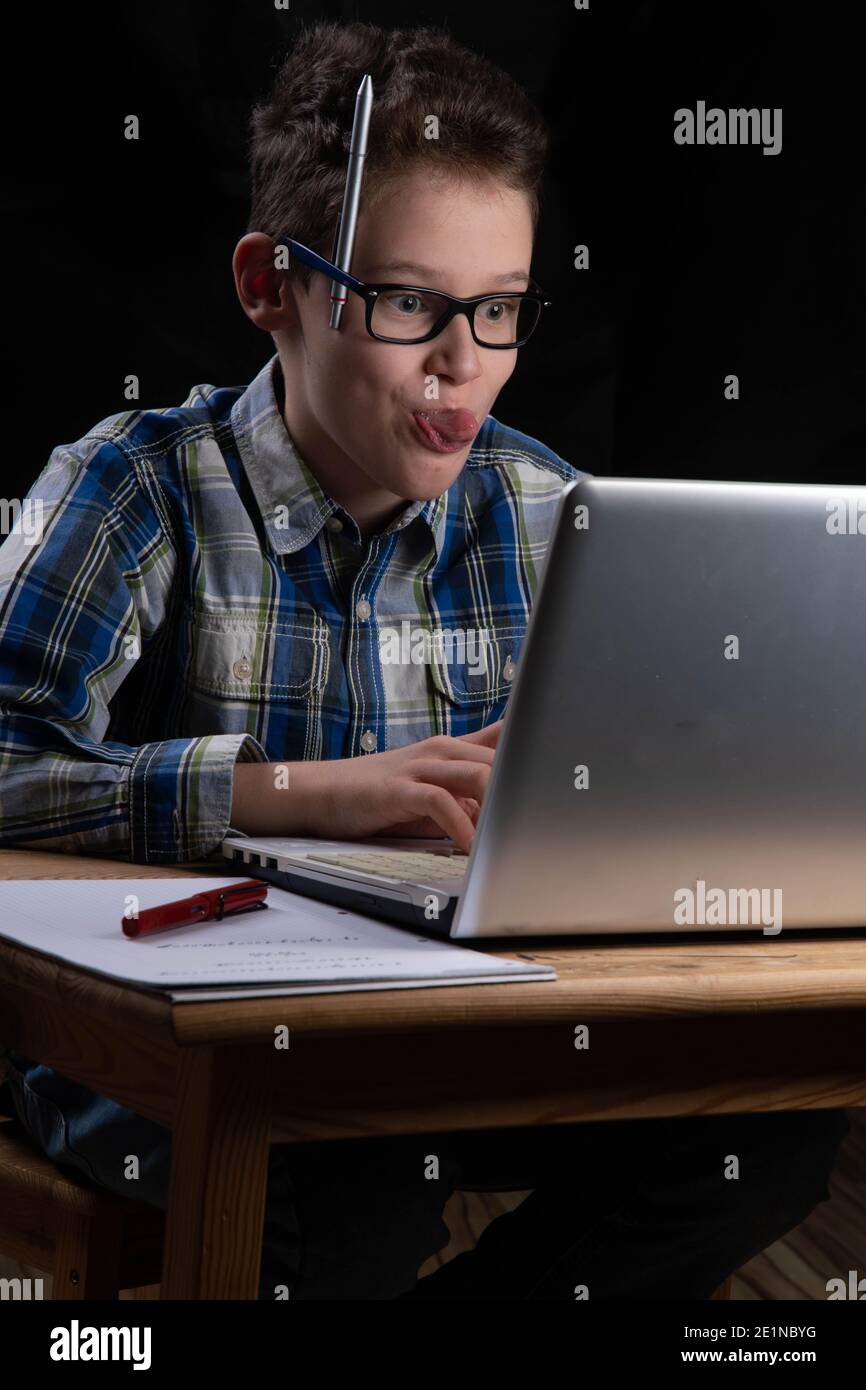 Boy funny on PC with tongue out on laptop Stock Photo