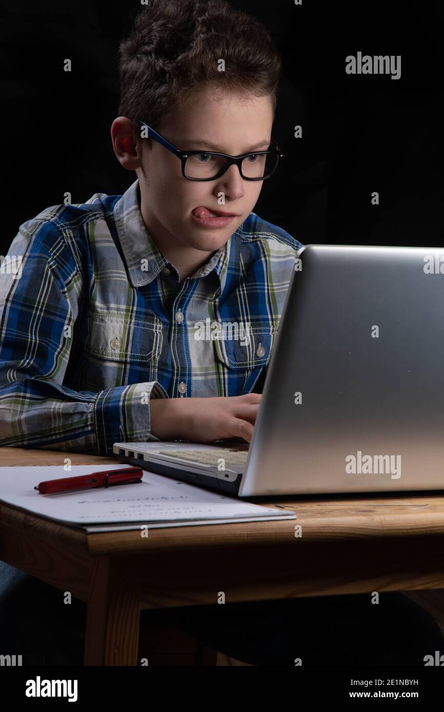 Boy funny on PC with tongue out on laptop Stock Photo