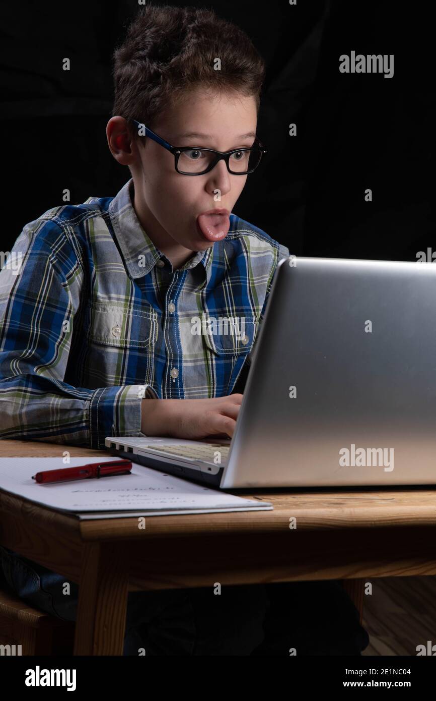 Boy funny on PC with tongue out on laptop Stock Photo