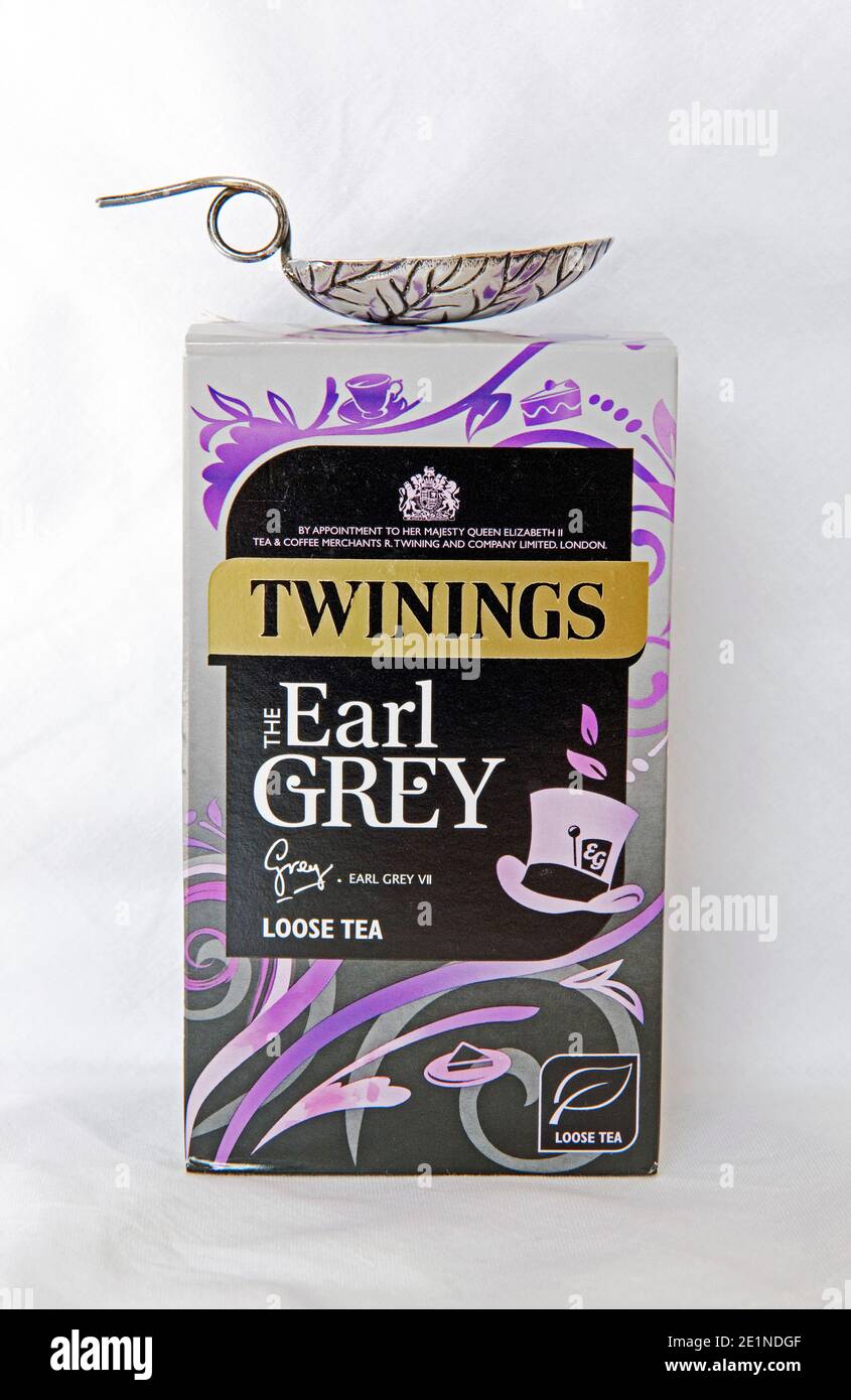 Packet of Twinings Earl Grey loose leaf tea with silver leaf patterned teaspoon on top against white cloth background Stock Photo